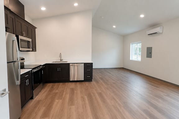 A kitchen with wooden floors and stainless steel appliances.