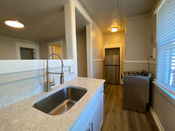A kitchen with a sink and a refrigerator.
