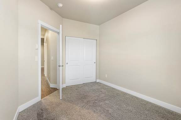 a bedroom with a carpeted floor and a white door