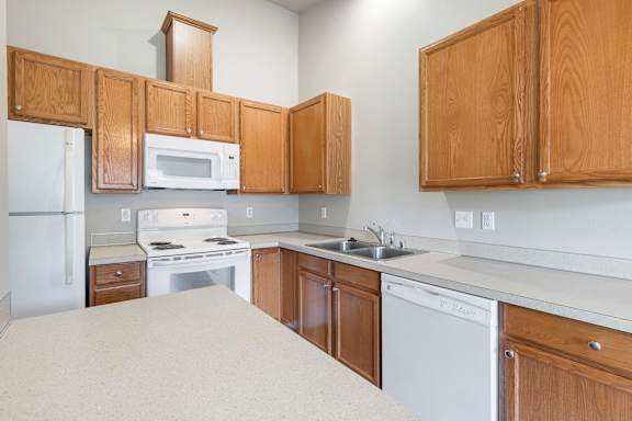 A kitchen with wooden cabinets and white appliances.