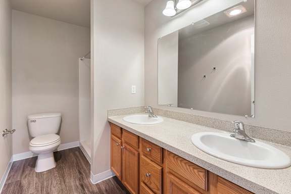 A bathroom with a toilet, sink, and mirror.