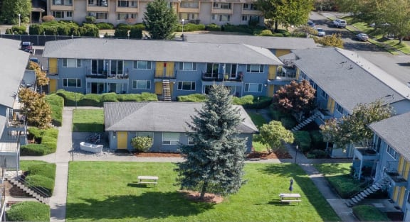 an aerial view of an apartment complex with green grass and trees