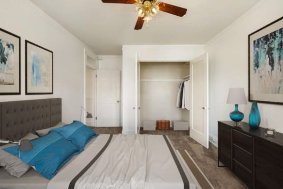 a bedroom with a large bed and a ceiling fan