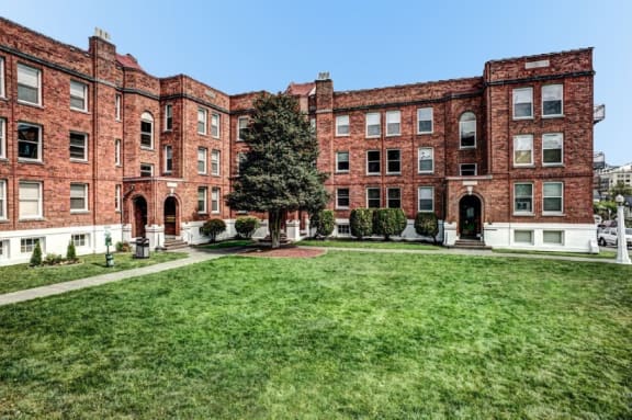 a large red brick building with green grass in front of it