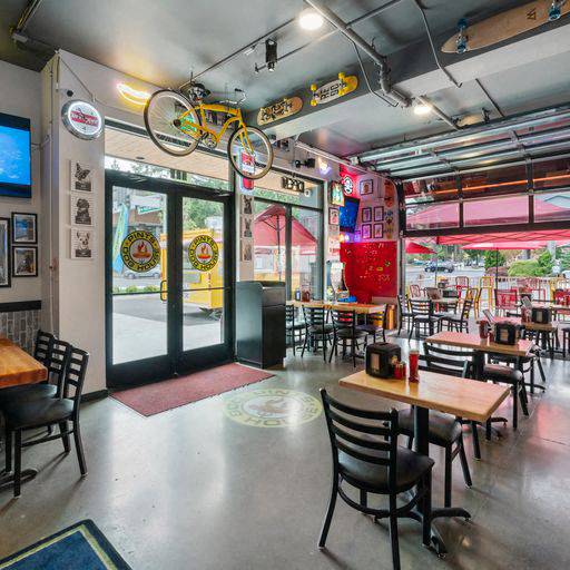 A restaurant with tables and chairs and a bicycle hanging from the ceiling at The Hub Apartments, Lacey, WA