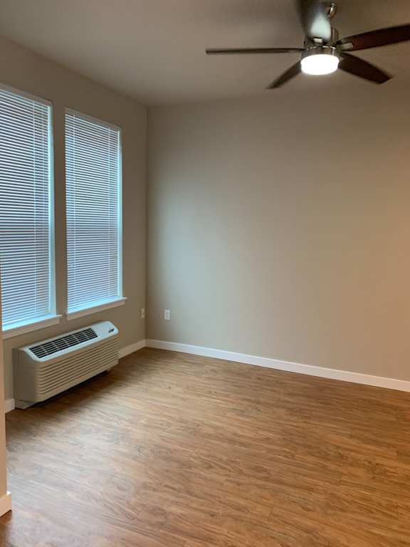 A ceiling fan is mounted on the wall above a window with blinds.