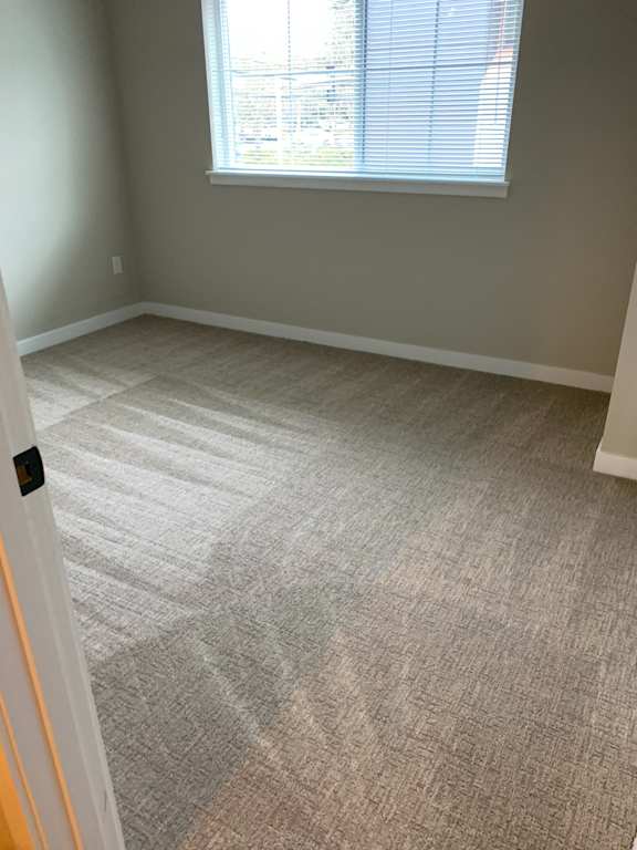 A room with a window and a wallpapered wall.