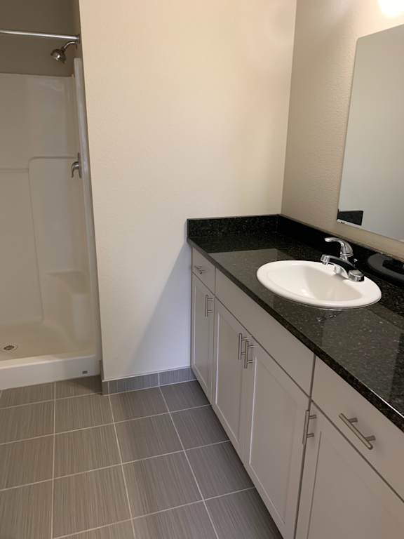 A white sink is mounted under a black countertop.