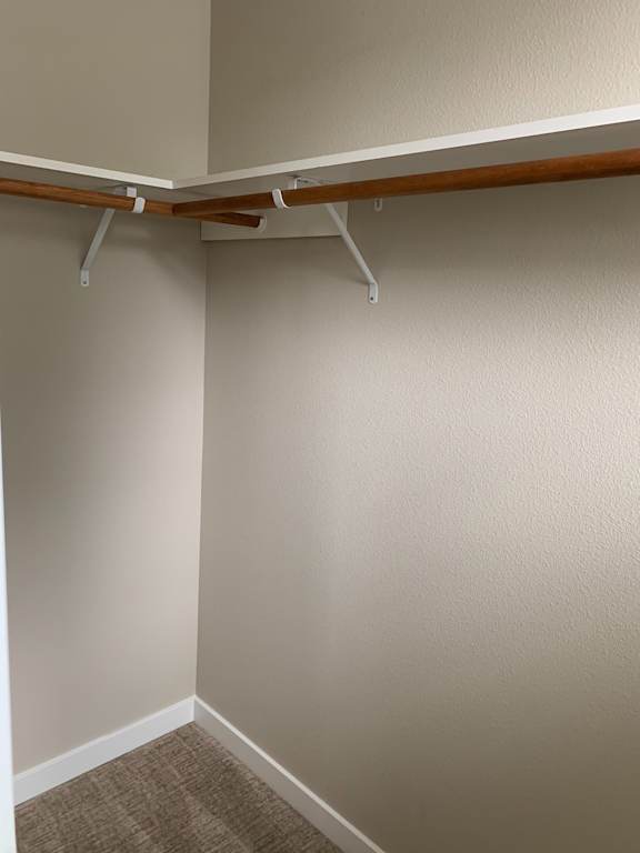 A white wall with a brown pole and a white rail.