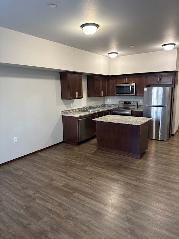 A modern kitchen with a wooden cabinet and a white countertop.