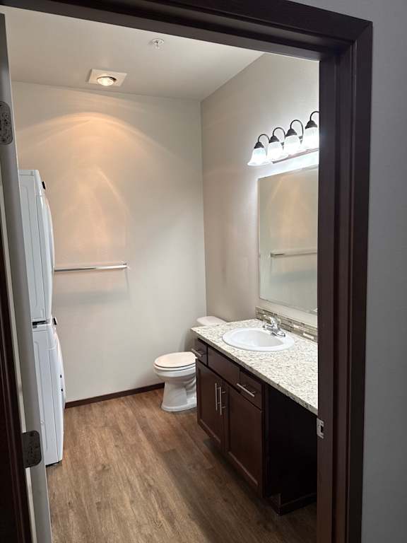 A white toilet is in a small bathroom with a wooden wall.