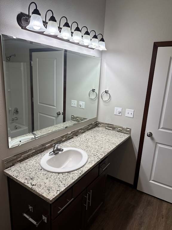 A bathroom with a sink, mirror, and toiletries.