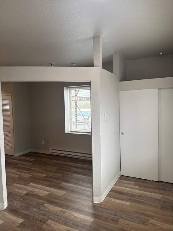 A white shelf is attached to a wall with wood paneling.
