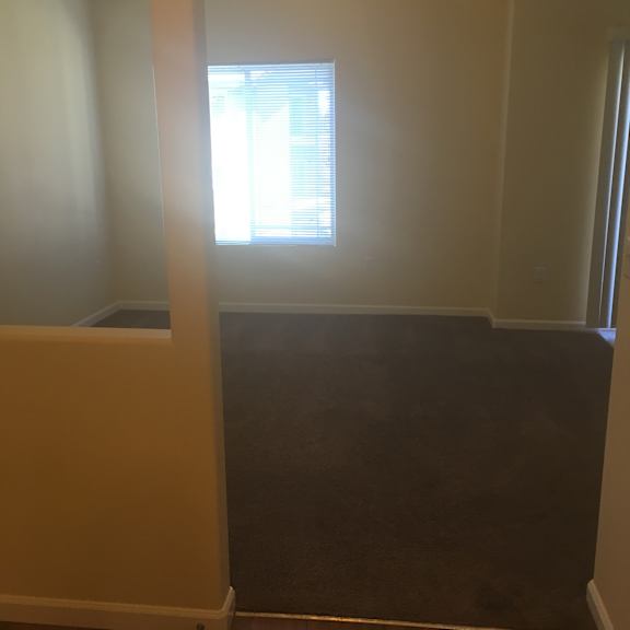 A window with blinds is in a room with a brown wall.