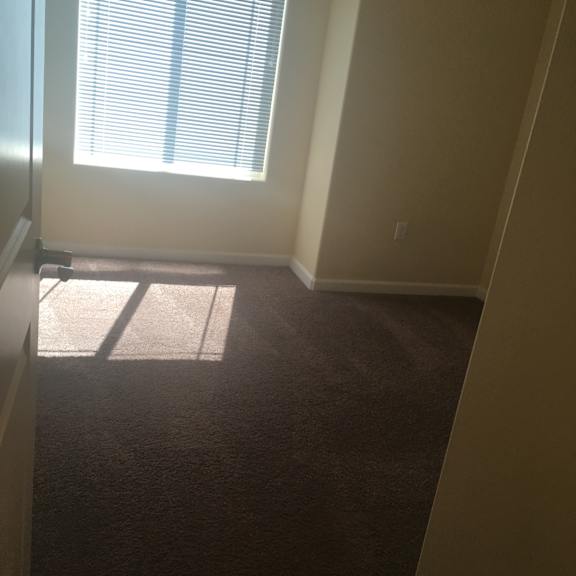 A room with a window and a wall with a shadow.