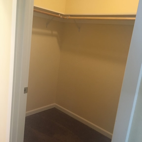 A white door is open to a room with a brown floor.