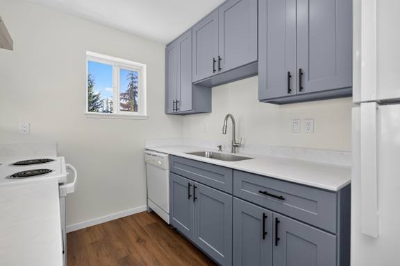 A kitchen with a white stove and a white refrigerator.