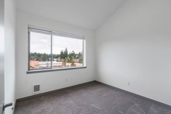 A room with a large window overlooking a residential area.