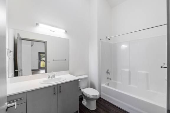 A white bathroom with a toilet, sink, and bathtub.