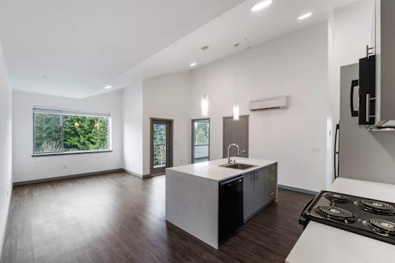 A modern kitchen with a large island and stove top.