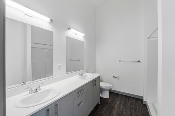 A white bathroom with a toilet, sink, and mirror.