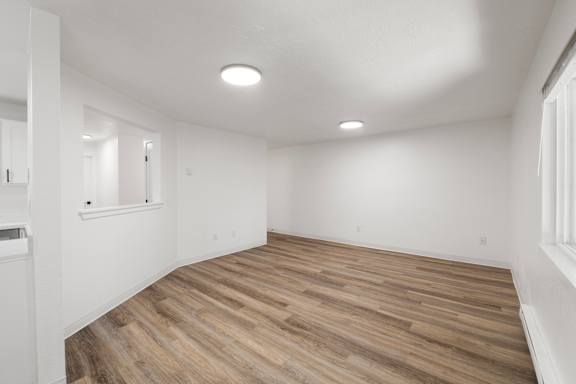 A room with wooden flooring and white walls.