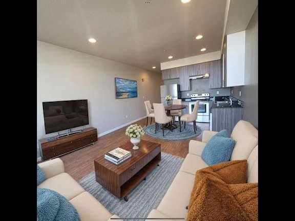 A modern living room with a flat screen TV, a coffee table, and a couch.