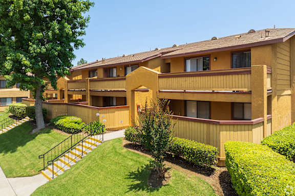 A yellow building with a tree in front of it.