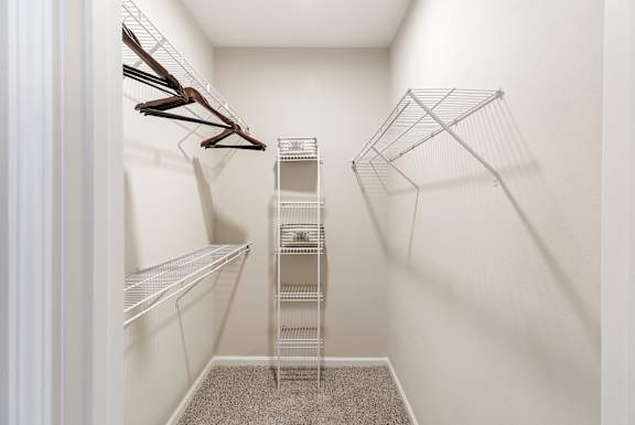 a spacious walk in closet with white walls and metal shelves at Cumberland Place Apartment Homes, Texas 75703