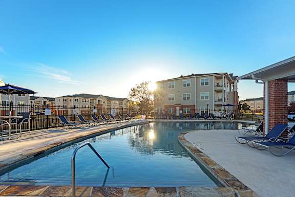 an apartment building with a green lawn and a sidewalk at Cumberland Place Apartment Homes, Tyler 75703