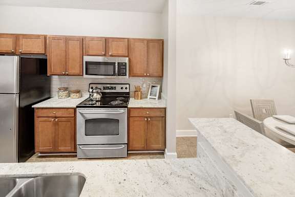 Kitchen with a stove top oven and microwave built into the cabinetry at Highlands Apartment Homes, Tennessee , 38135