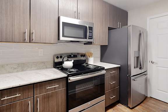 a kitchen with stainless steel appliances and wooden cabinets at Bridgewater Apartment Homes, Mississippi 39047