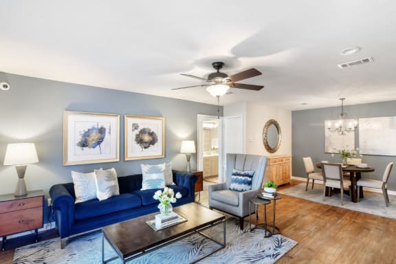 a living room with a blue couch and a ceiling fan at Bridgewater Apartment Homes, Brandon, 39047