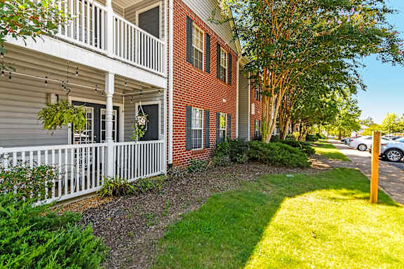 A red brick building with a white balcony at Crossgates Apartment Homes, Starkville, Mississippi