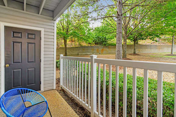 A blue chair sits on a porch with a white railing Lexington Pointe Apartment Homes in Oxford, MS