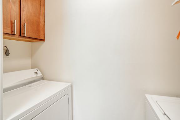 a washer and dryer in a laundry room with white walls at Cambridge Station Apartment Homes in Oxford, MS