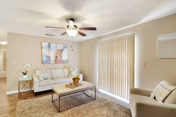 a living room with a ceiling fan and a couch  at Parklane Apartment Homes, McComb, MS