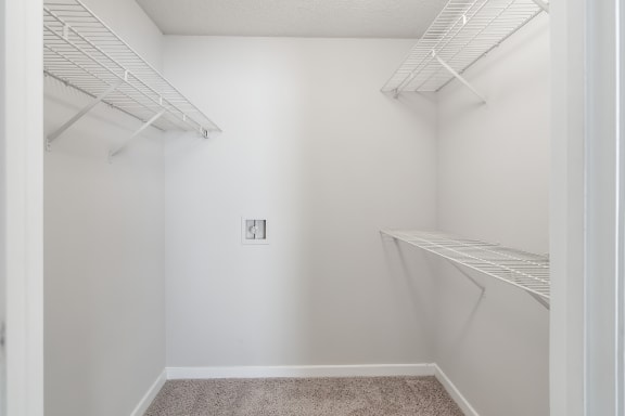 an empty closet with white walls and shelves and a white walled closet with shelvesat The Pointe Apartment Homes, Gautier, 39553