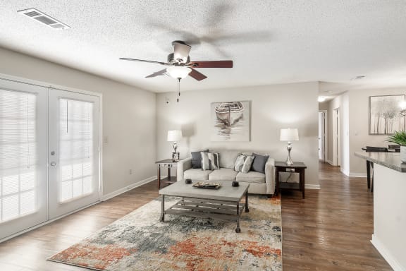 a living room with a couch and a ceiling fanat The Pointe Apartment Homes, Mississippi