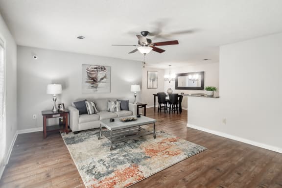 a living room with hardwood floors, a couch and a ceiling fanat The Pointe Apartment Homes, Gautier, 39553