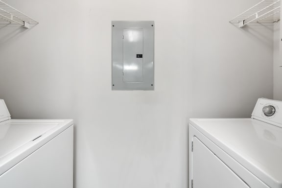 a washer and dryer in a white laundry roomat The Pointe Apartment Homes, Gautier, MS