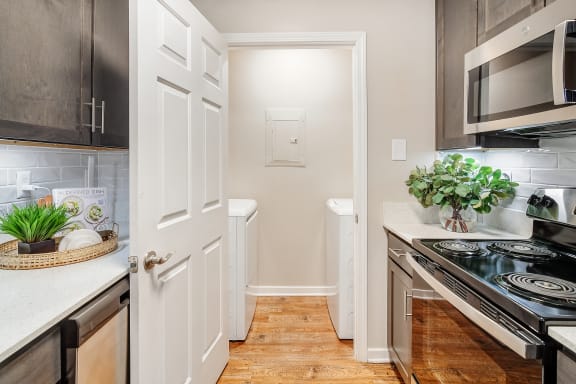 a small kitchen with a stove and a microwave at Reserve of Jackson Apartment Homes, Mississippi