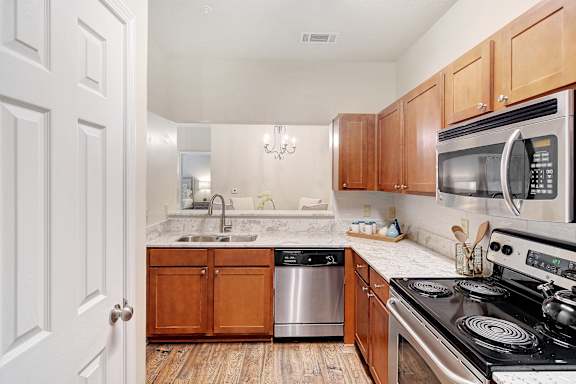 A kitchen with a stove, sink, and cabinets at Summit of Shreveport Apartments, Shreveport, LA