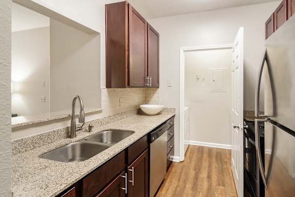 A kitchen with a sink, refrigerator, and cabinets at Highpointe Apartment Homes, Brandon