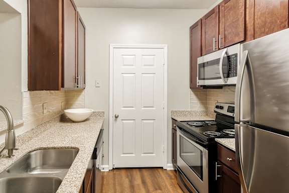 Kitchen with stainless steel appliances and granite countertops at Highpointe Apartment Homes, Brandon, 39042
