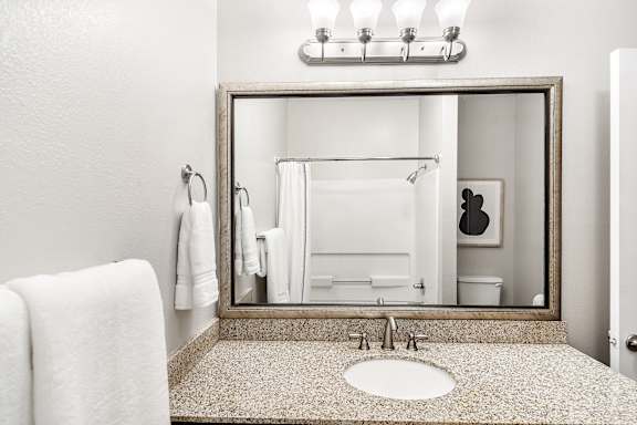 Bathroom with a sink, mirror, and towel at Highpointe Apartment Homes, Brandon, Mississippi