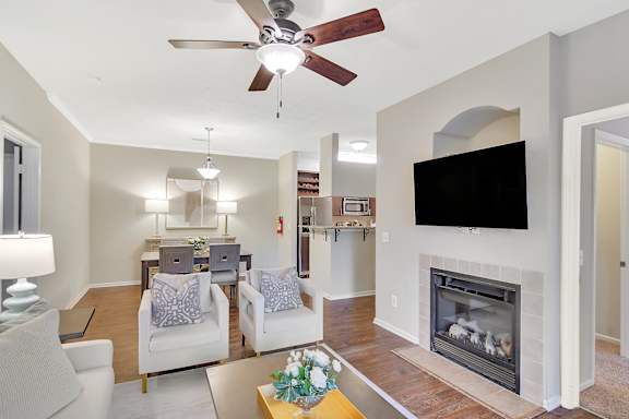 A living room with a fireplace and a television at Ashford Place Apartment Homes, Flowood, 39232