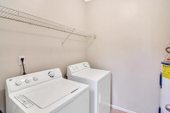 A white washing machine and dryer in a laundry room at Ashford Place Apartment Homes, Flowood, MS 39232