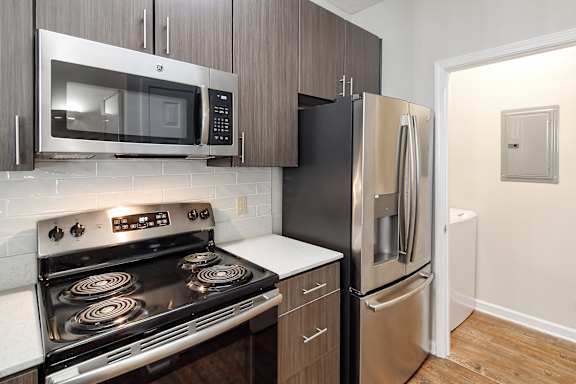 a kitchen with stainless steel appliances and a refrigerator at Legacy Apartment Homes in Ridgeland, MS