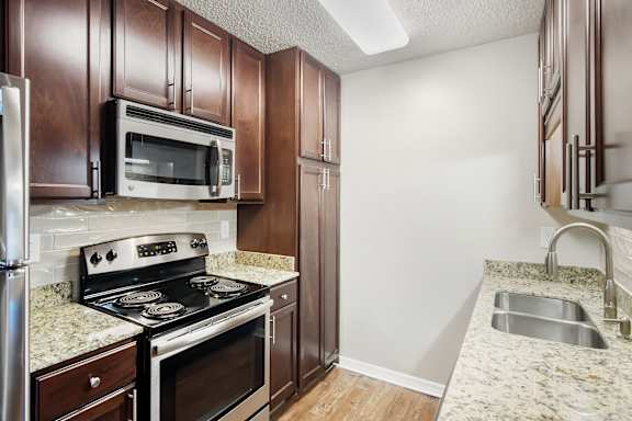 A kitchen with a stove, microwave, and refrigerator  at Lakeshore Pointe Apartment Homes, Brandon